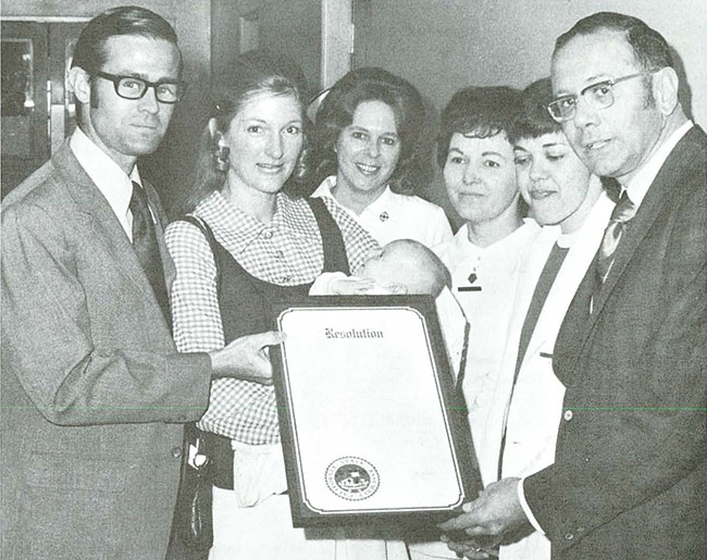 group of 6 people surrounding an award that's being presented