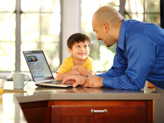 young boy sitting at kitchen counter with father