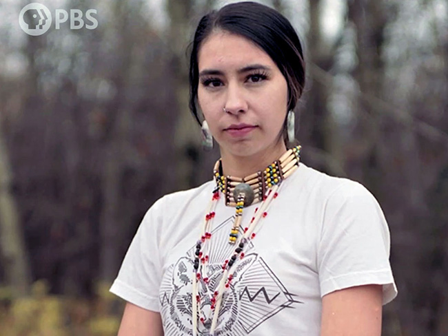 young Native American woman standing outdoors wearing Native American jewelry
